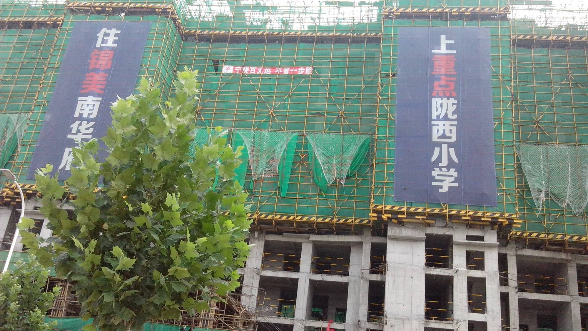 项目广告语:住锦美南华府,上重点陇西小学,售楼部沙盘边展示有开发商